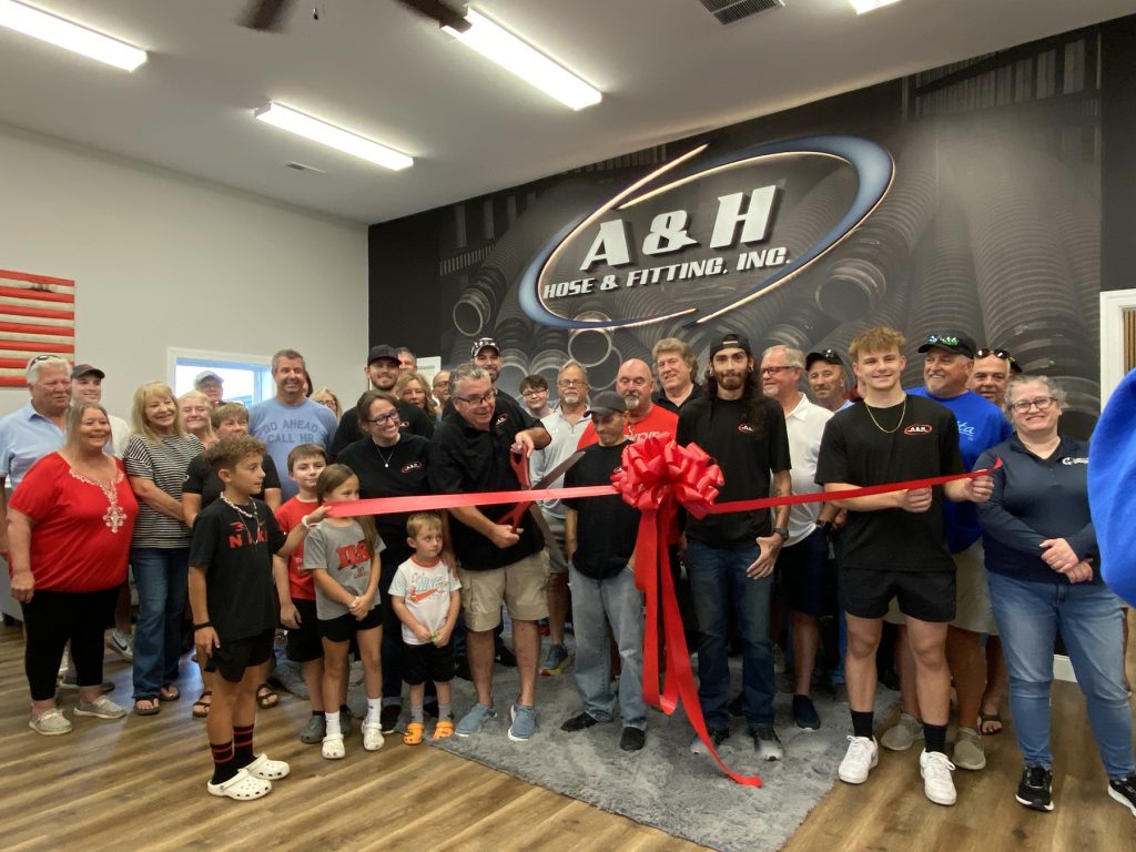 A & H Hose employees stand in the newly designed lobby for a ribbon cutting ceremony.