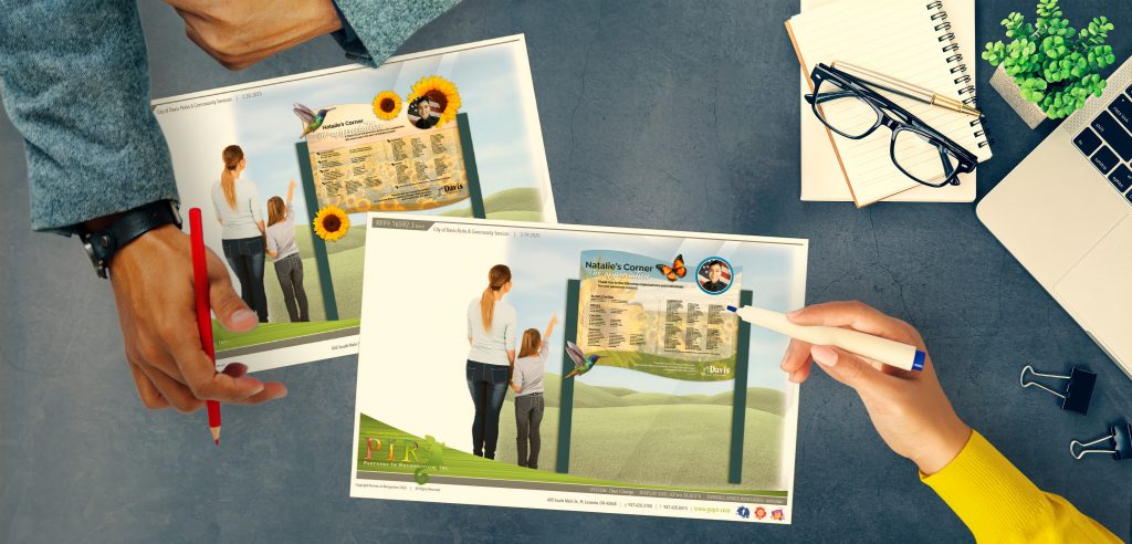 A sales consultant reviewing preliminary designs with a client for a donor recognition display.