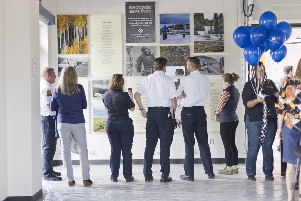 Employees and service men celebrating the unveiling of a donor display honoring the community they serve.