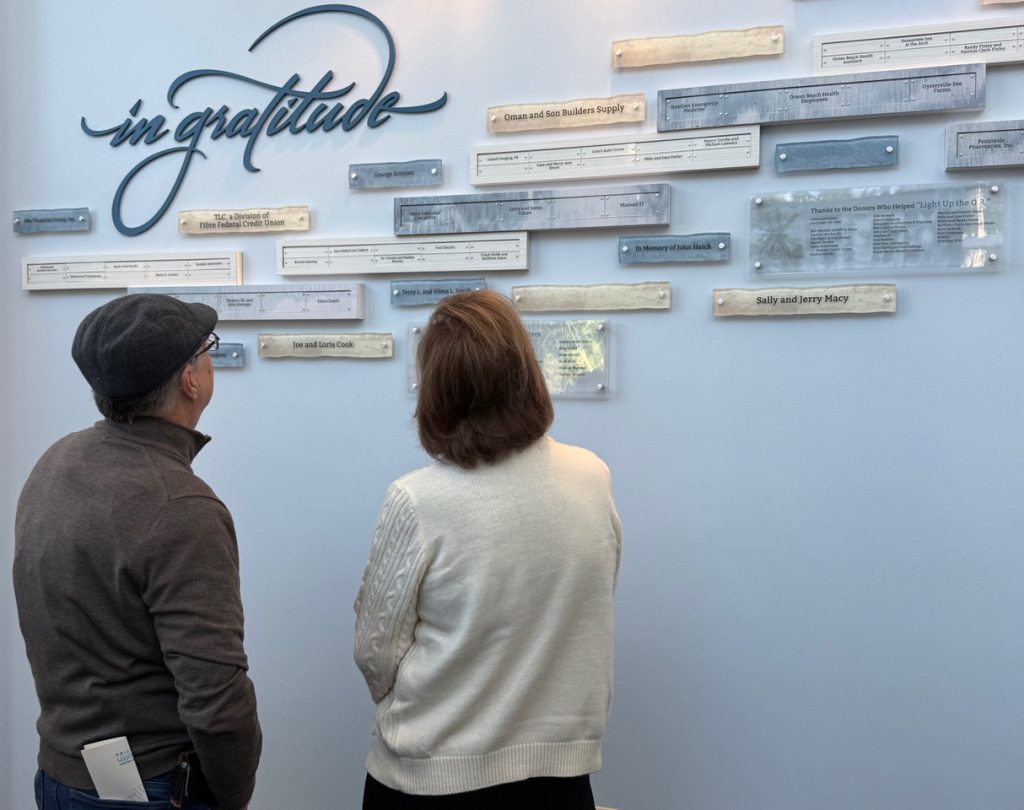 Attendees interacting with the donor recognition wall during the unveiling event, reflecting community response and donor pride.