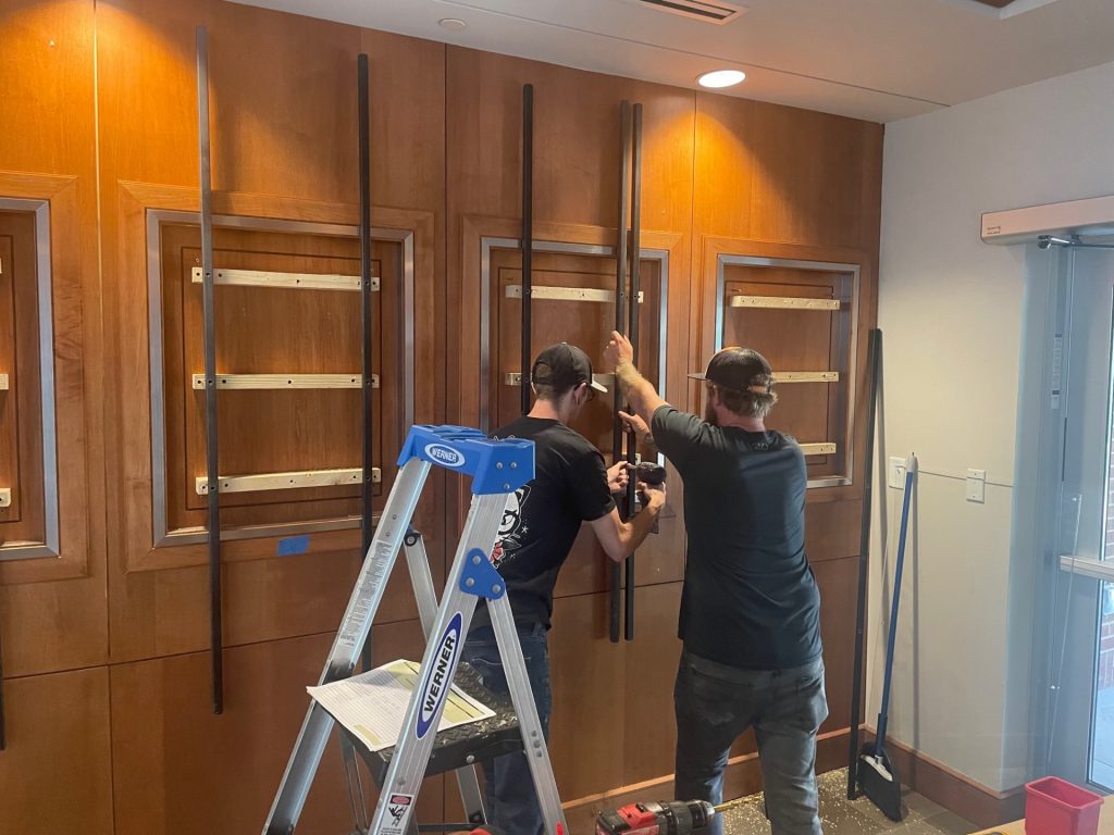 Installers installing the structural supports for an awards wall at the University of Tennessee, Knoxville.