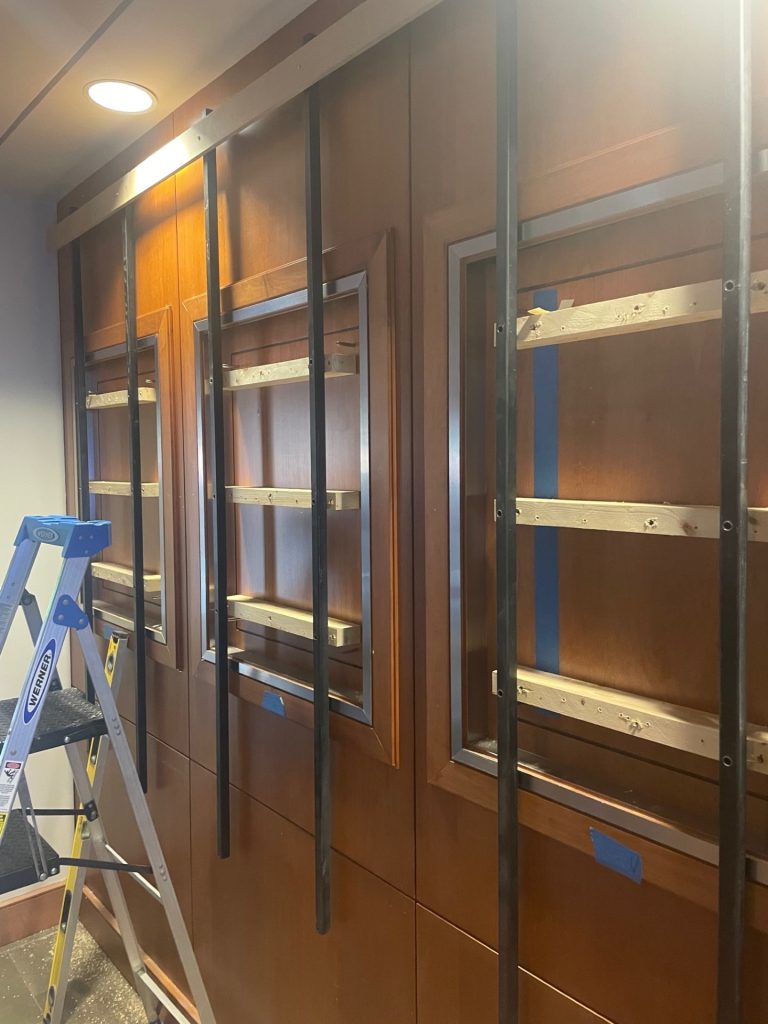 Custom university award wall at Haslam College of Business engineered with a non-invasive mounting system.