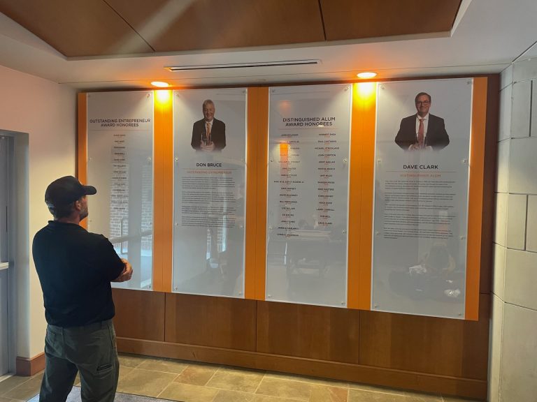 Modular university award display installed at Haslam College of Business using non-invasive mounting system.