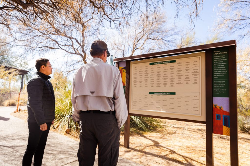 Community engaged with an outdoor donor wall in the desert.
