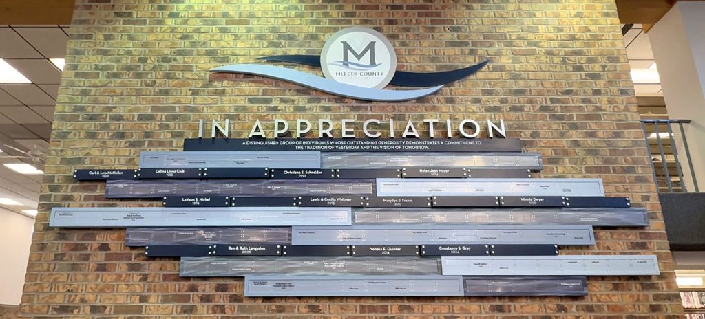 Donor recognition display combining multiple plaques into one cohesive system at Mercer County District Library.