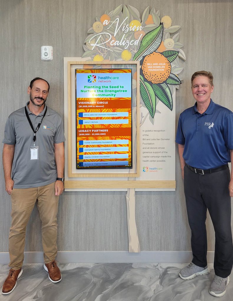 Completed hybrid healthcare donor recognition wall with PIR representative and Healthcare Network team member