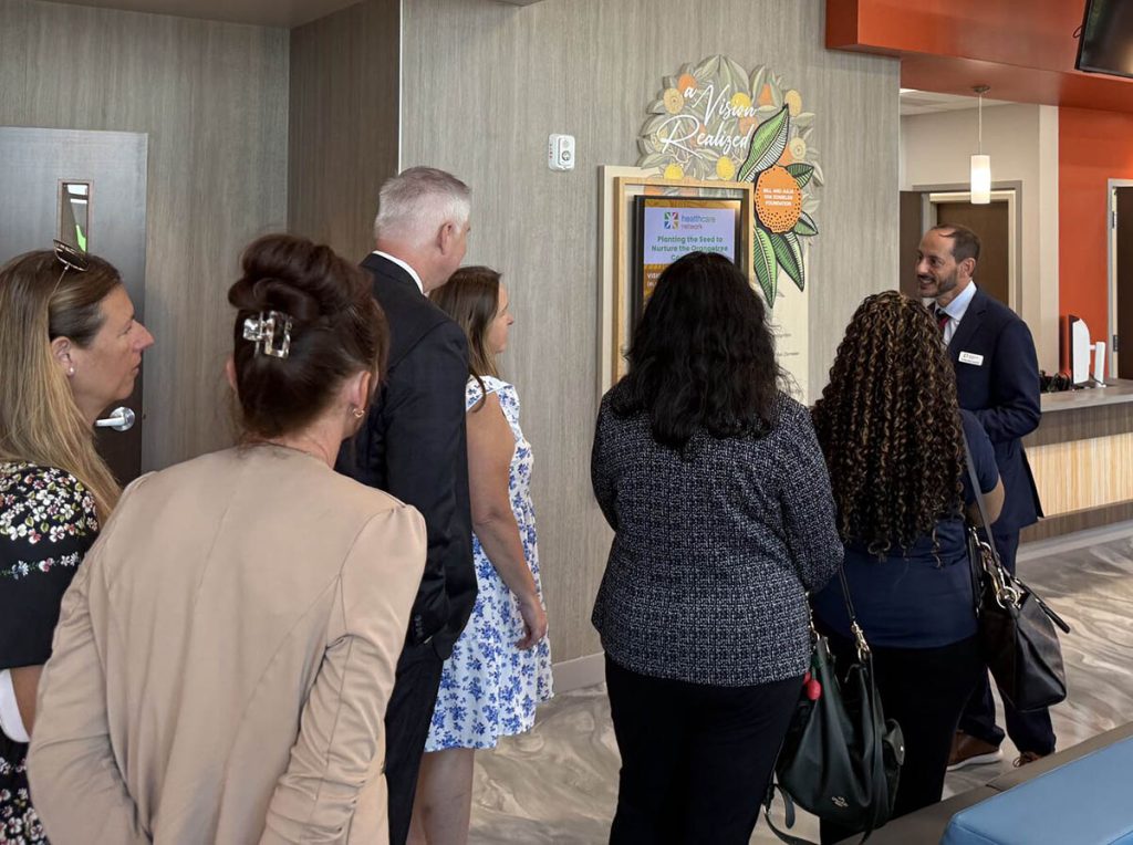 Healthcare Network visitors viewing hospital donor recognition display during opening event