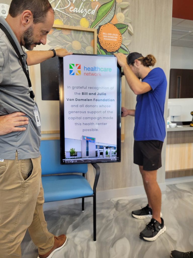 PIR installers adapting hospital donor recognition display mounting during installation