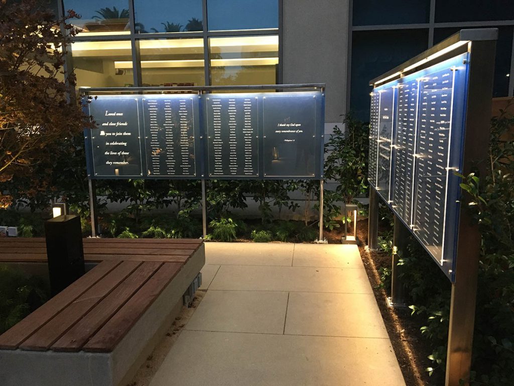 Illuminated outdoor memorial display with donor name panels at Hoag Hospital garden at night