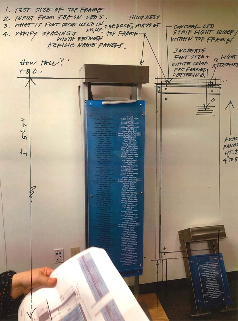 Prototype of outdoor memorial display panel with blue acrylic, LED lighting concept, and handwritten design notes