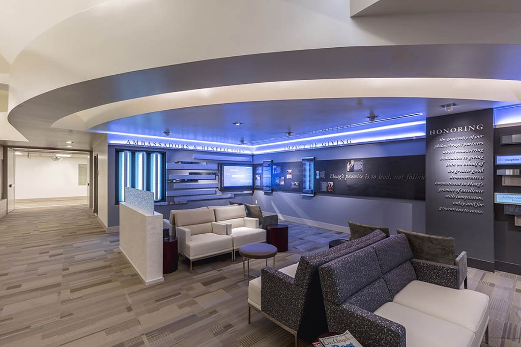 Large healthcare donor recognition environment integrated into a hospital lobby with digital displays, donor panels, and architectural lighting.