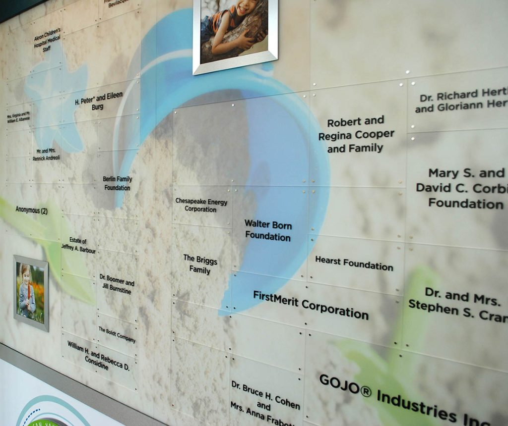 Hospital donor recognition wall displaying numerous donor names on custom graphic panels and acrylic recognition components.