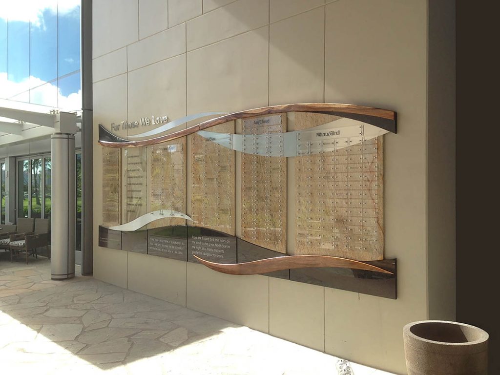 Outdoor donor recognition display featuring curved architectural elements, glass panels, and custom fabricated donor name sections.