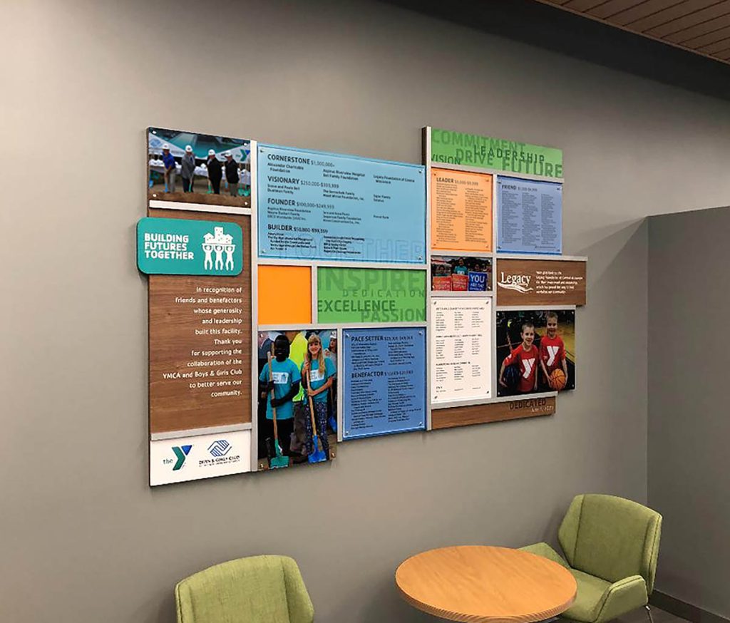 Colorful YMCA donor recognition wall featuring multiple materials, donor categories, graphics, and dimensional design elements.