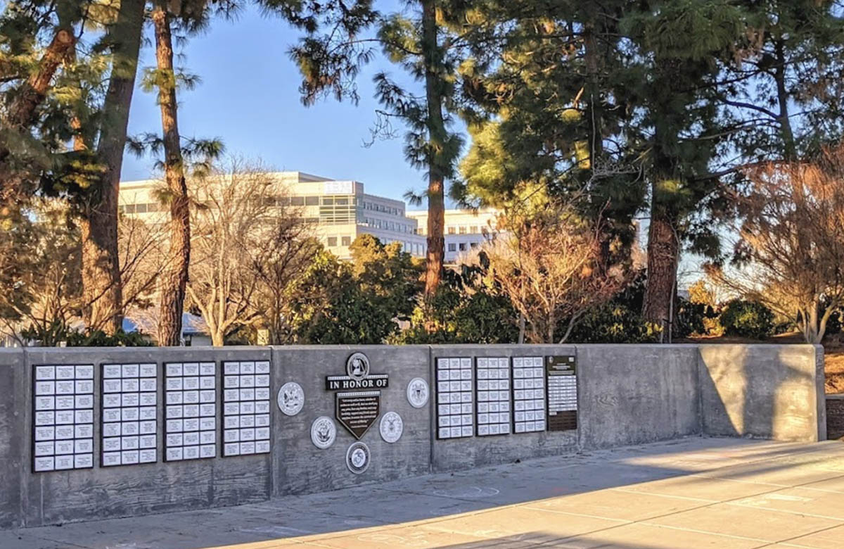 Completed outdoor veteran's recognition wall featuring expandable nameplate panels.
