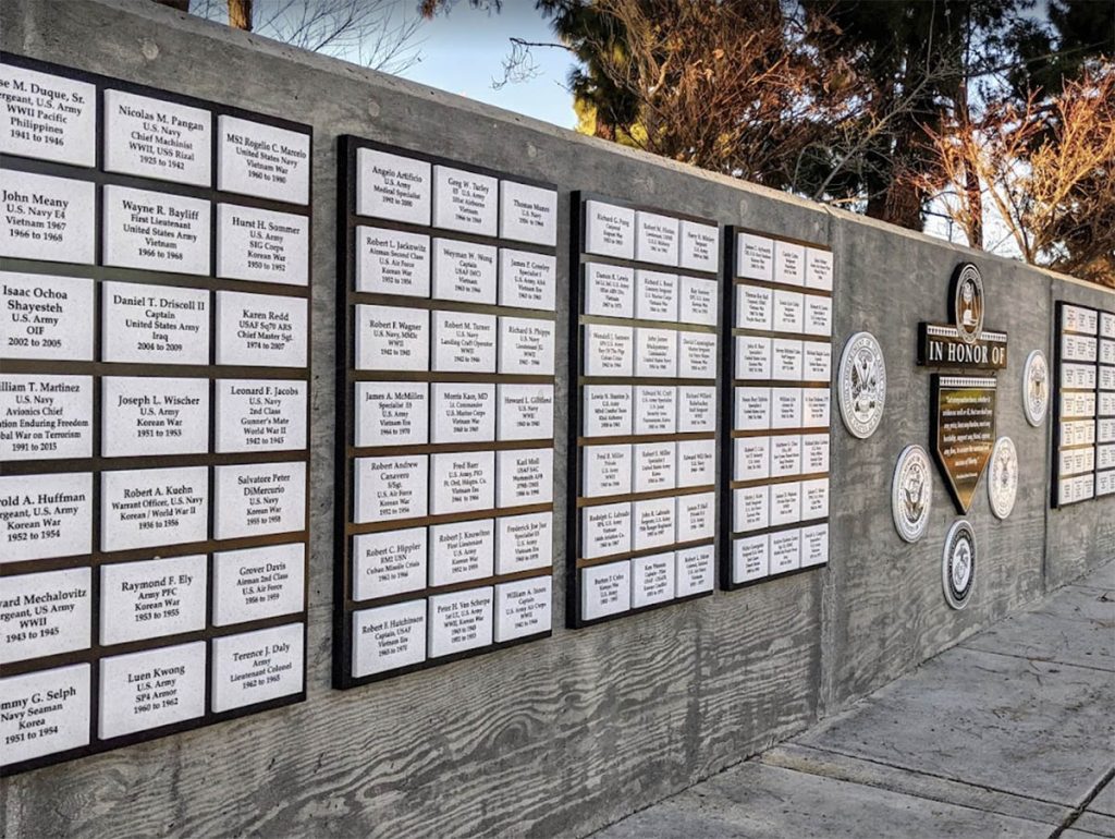 Detail view of engraved veteran nameplates and military service emblems.