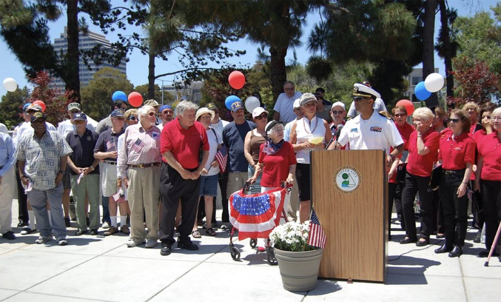 Community members gathered at an outdoor veteran's recognition wall dedication ceremony.