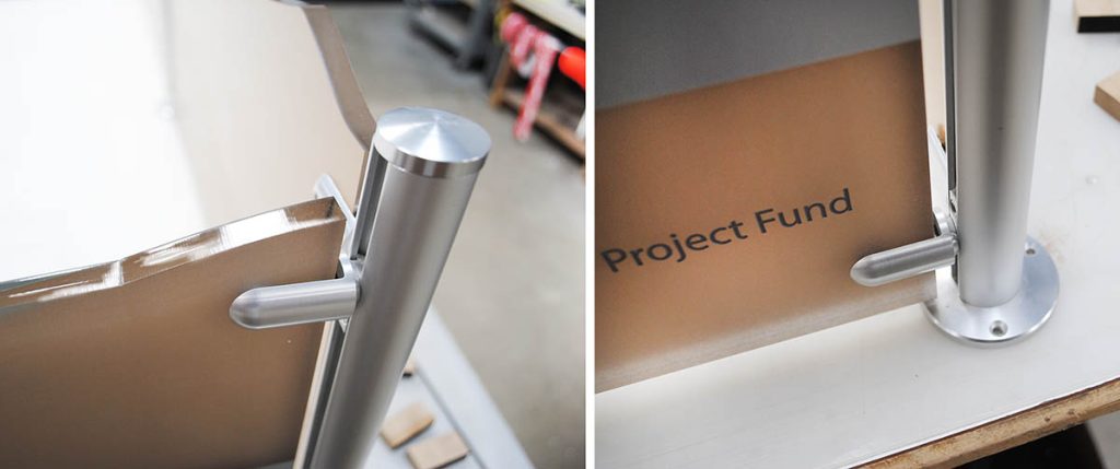 Close-up of brushed stainless steel hardware securing the acrylic panels on a healthcare donor recognition display.
