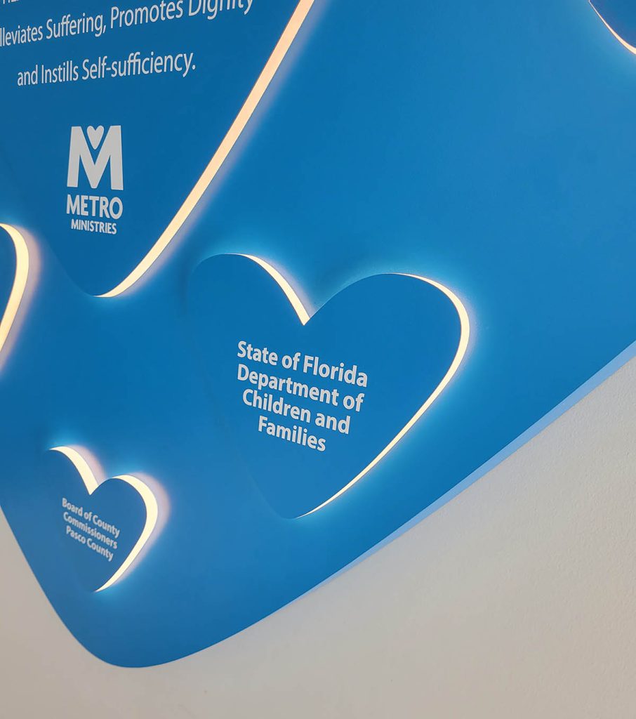 Close-up of a faith based donor recognition display featuring illuminated Ember Glow™ heart-shaped donor plaques for Metropolitan Ministries.