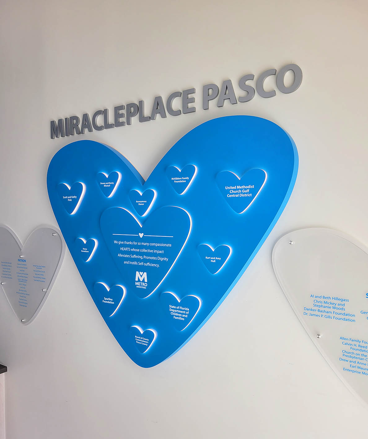 Faith based donor recognition display for Metropolitan Ministries featuring Ember Glow™ illuminated heart donor plaques and Clear Change™ recognition panels.