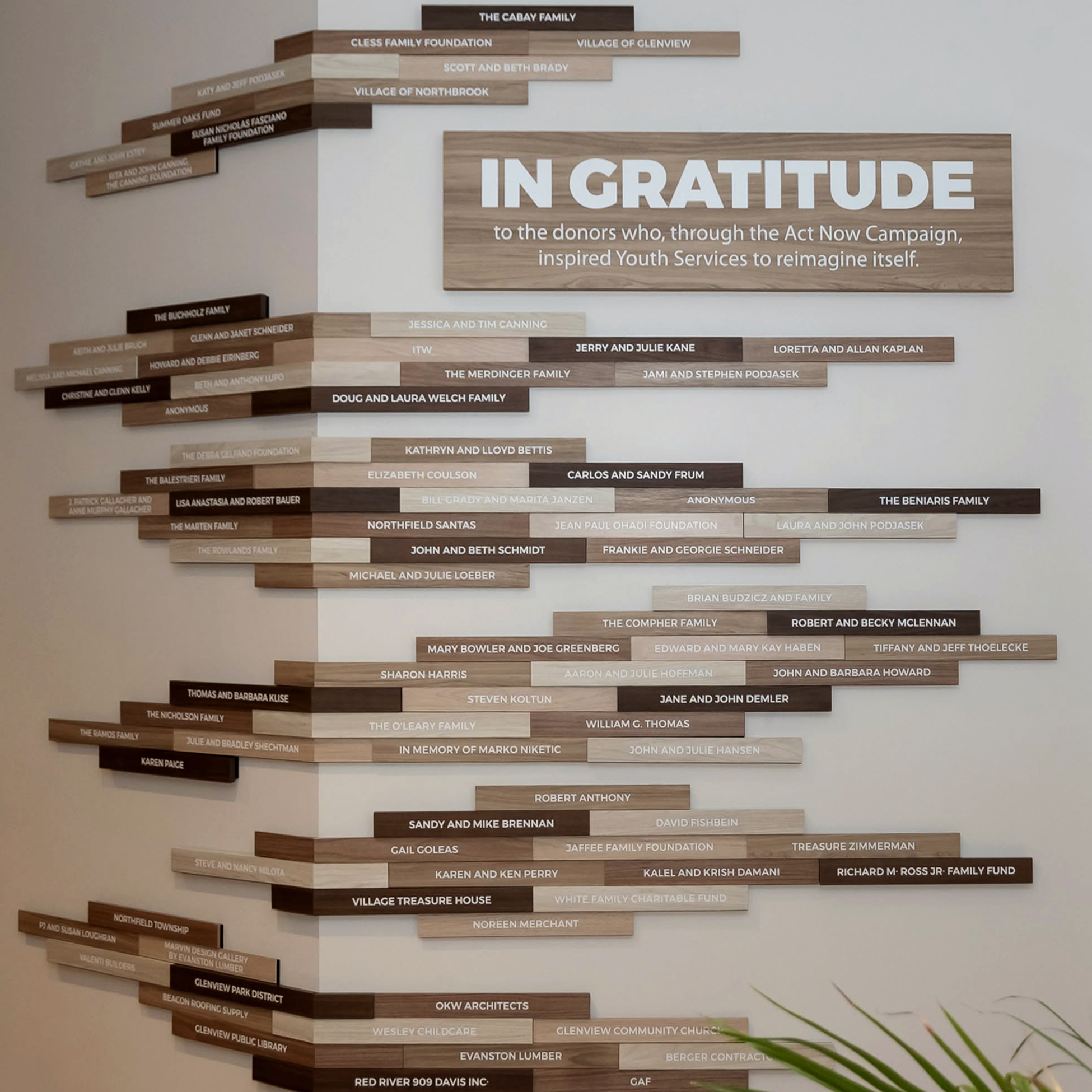 Youth Services nonprofit donor recognition display featuring staggered wood-tone nameplates in varying sizes and an “In Gratitude” recognition panel.